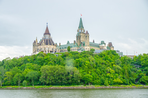 Rear view of Library and Parliament of Canada with Ottawa river during summer day.