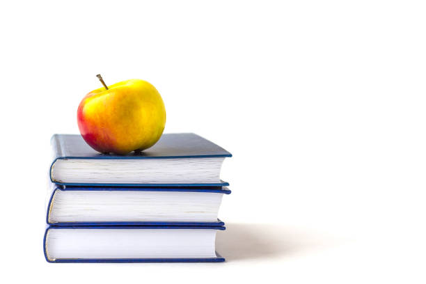 istock Education or back to school concept. An appleon a stack of books isolated on a white background with copy space. 1267535518