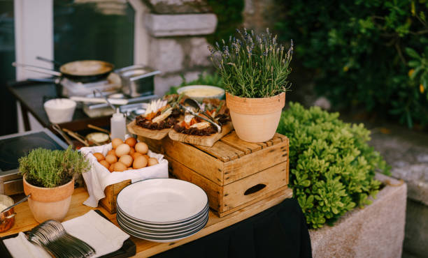 istock Table with chicken eggs, wooden cutting board with cheese and prosciutto and lavender flowerpots. 1267540083