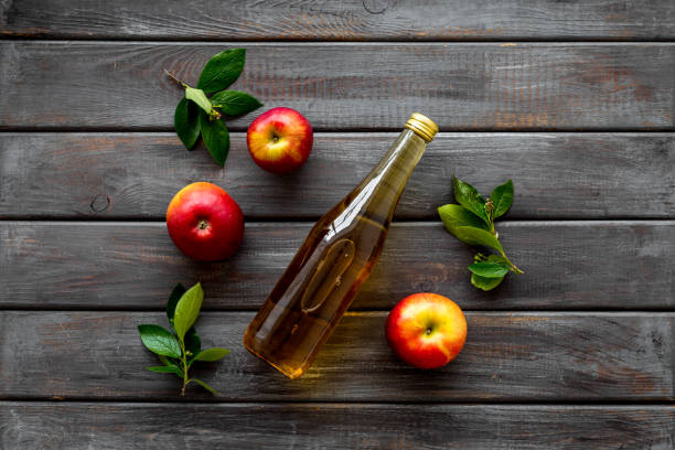 istock Apple cider vinegar in bottle with fruits top view 1267541302