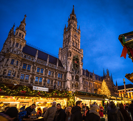 Munich, Germany - People browsing market stalls in a large winter market in Marienplatz in central Munich, with the New Town Hall in the background.