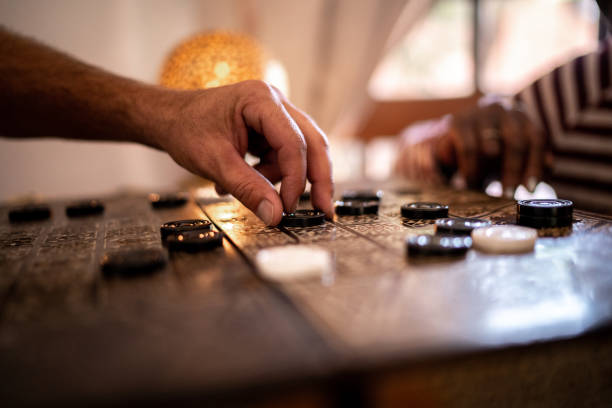 Cropped hand of a senior adult playing checkers on a tablet Cropped hand of a senior adult playing checkers on a tablet chinese checkers stock pictures, royalty-free photos & images