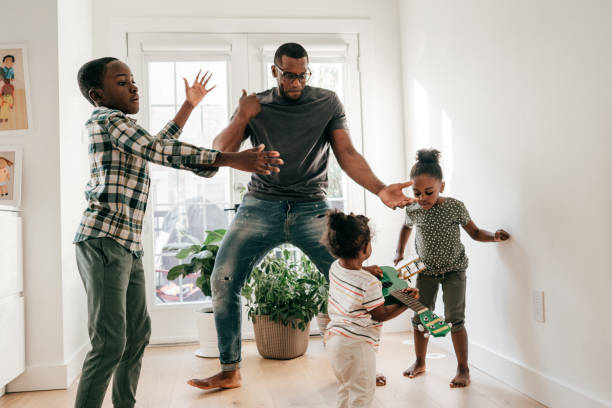 The Best Advice You'll Get On Homeschooling Right Now dad dancing with kids at home and they have fun father and son guitar stock pictures, royalty-free photos & images