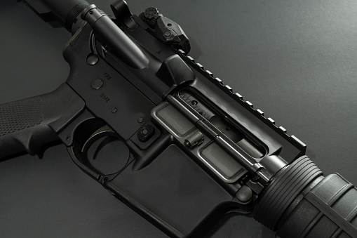 Black AR-15 laying on black background.