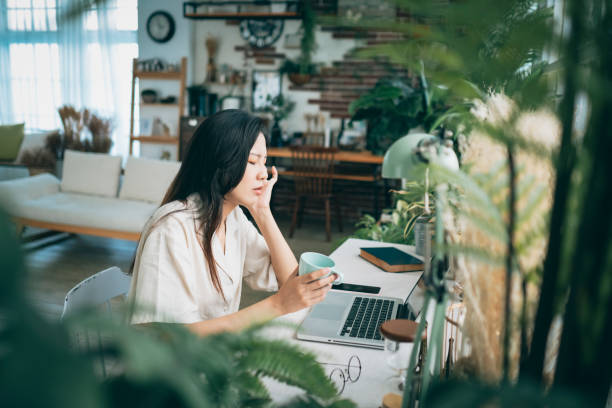 istock Asian woman struggling with using laptop at home 1267548880