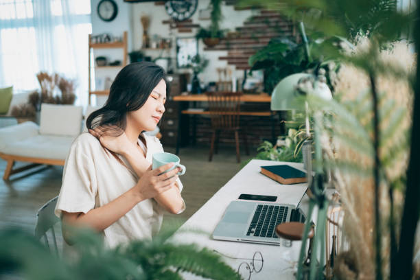 Asian woman struggling with using laptop at home