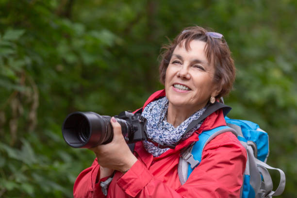istock Senior woman with camera in summer forest 1267551712