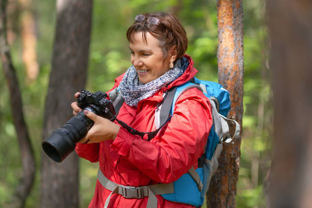 istock Senior hiker woman with camera in forest 1267551865