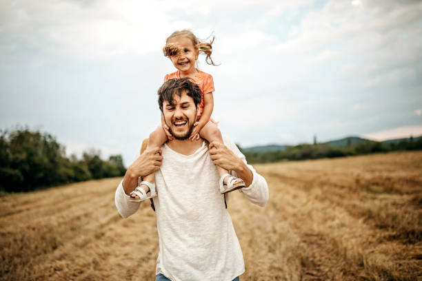 Happy with my dad Father caring kid on shoulders in nature on shoulders stock pictures, royalty-free photos & images