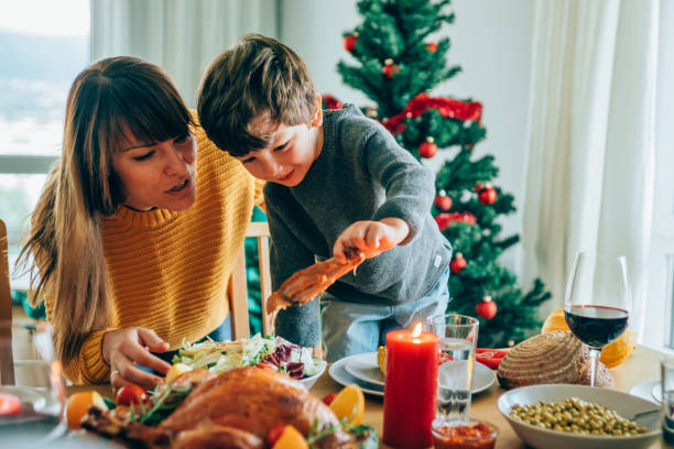 istock Happy mother and her son having fun while holding roasted turkey leg 1267558890