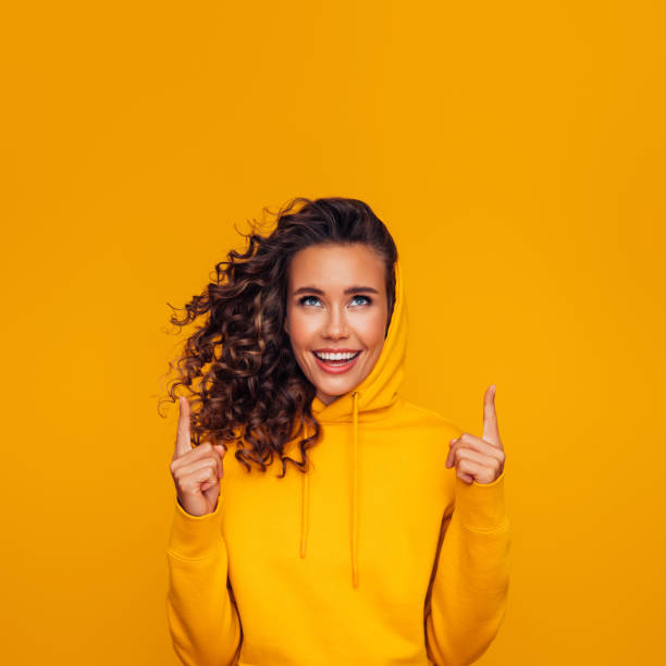 istock Beautiful woman smiling and pointing up 1267559966
