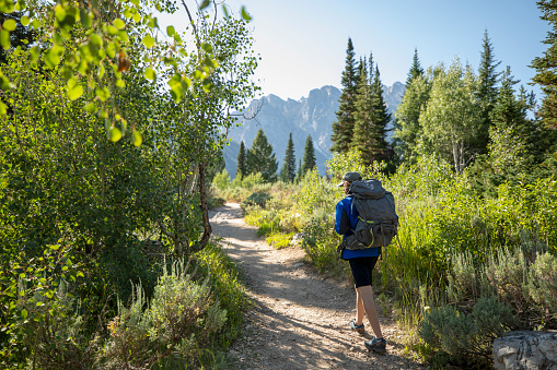 Young men with a backpack doing trail hiking in Grand Teton National Park, Wyoming.