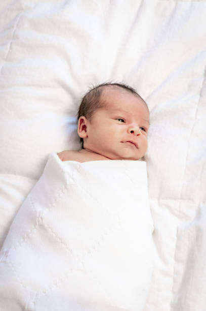 istock Newborn baby wrapped in white blanket 1267562587