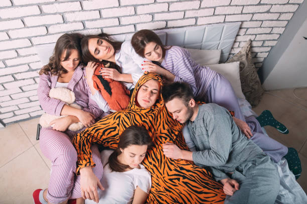 istock Sleeping group of young people on a bad. 1267562986