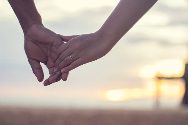 couple holding hands at the sunset - holding hands human hand romance support imagens e fotografias de stock