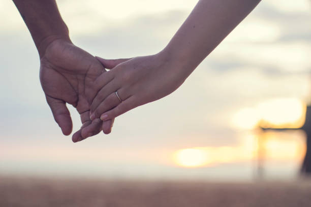 пара, держась за руки на закате - holding hands human hand romance support стоковые фото и изображения