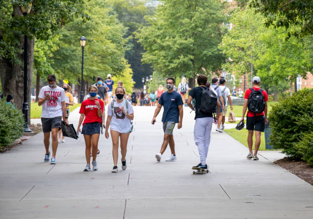 Students wear face coverings while walking on campus at the University of Georgia. stock photo