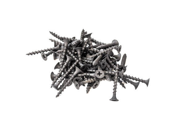 a pile of black steel screws isolated on a white background close up - expendable imagens e fotografias de stock