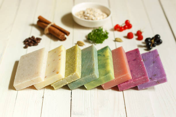 Pieces of colored soap with natural ingredients on a light wooden surface. horizontal orientation stock photo