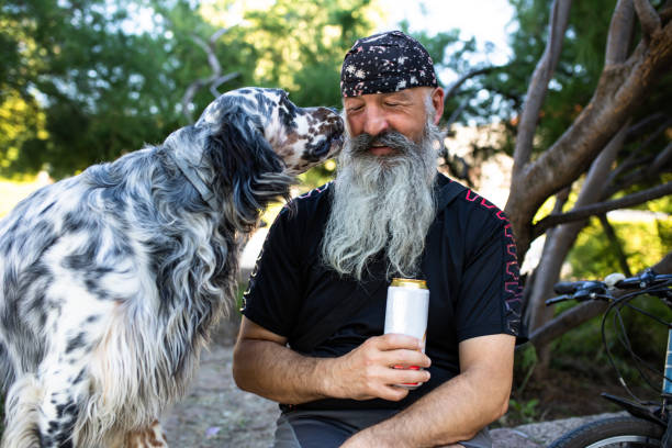 istock An old man smiling while a dog is sniffing his face 1267571855