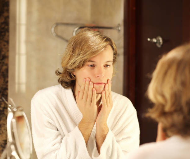 istock Applying the cream.young man looking in the mirror 1267571902
