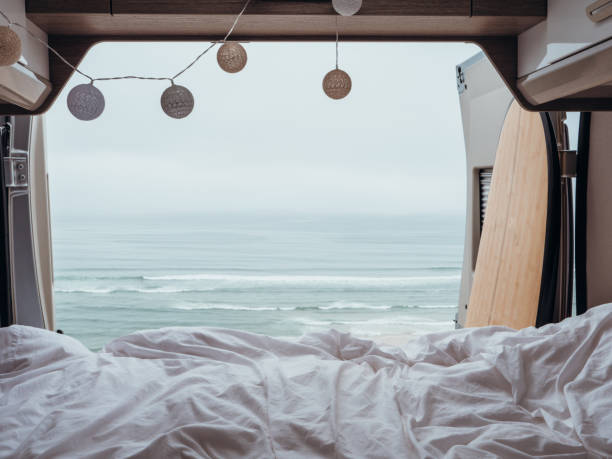 istock Back of a van overlooking the ocean, van life, bed view 1267574988