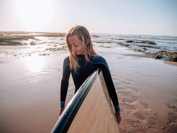 istock Surfer woman on the beach at sunrise 1267575864