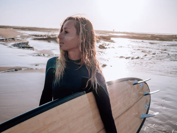 istock Surfer woman on the beach at sunrise 1267576314