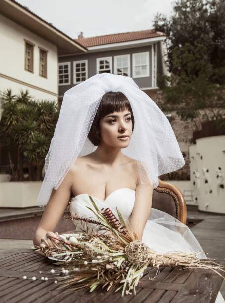 istock Beautiful bride looks great with her veil while relaxing. 1267577566