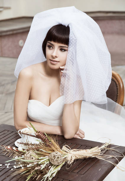istock Beautiful bride looks great with her veil while relaxing. 1267578288