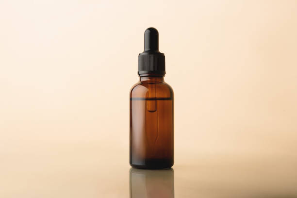 istock Serum glass bottle with pipette on beige reflectivebackground. 1267578448