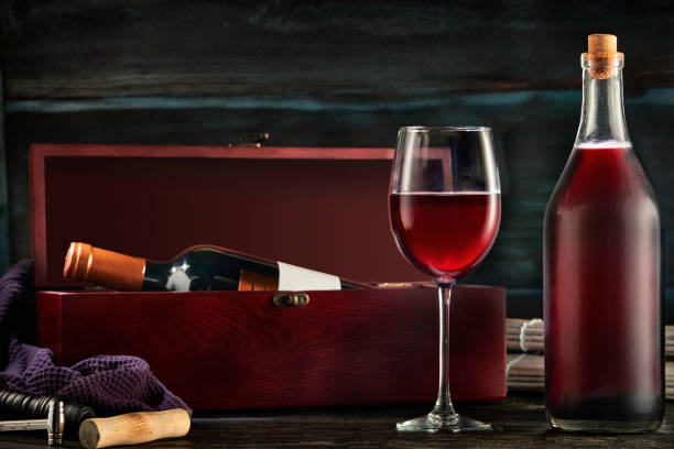 istock Low key image of red wine bottle and cup in a rustic nautical environment bar 1267579524