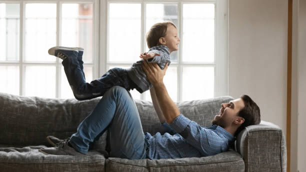 istock Happy young daddy playing airplane with boy son. 1267591959