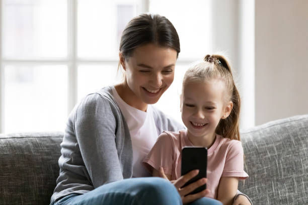 istock Smiling young mother showing funny mobile application to kid. 1267591963