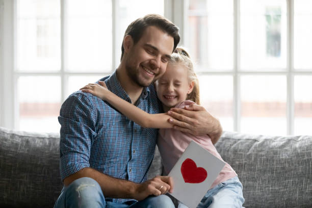 istock Thankful young smiling handsome daddy embracing little daughter. 1267591977