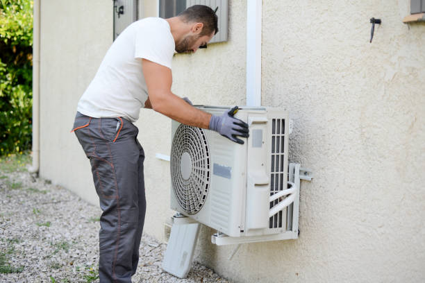 handsome young man electrician installing an air conditioning in a client house handsome young man electrician installing an air conditioning in a client house cooling rack photos stock pictures, royalty-free photos & images