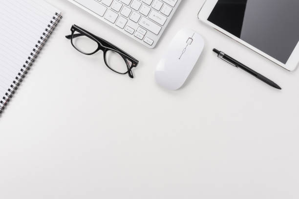 istock Workspace with computer keyboard, office supplies, and tablet on white background. Top view with copy space. 1267594732