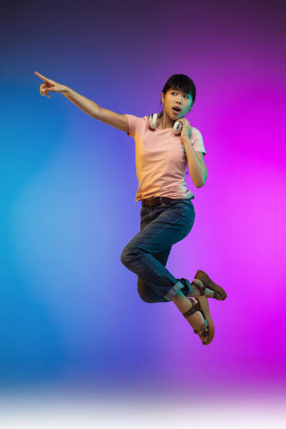 istock Asian young woman's portrait on gradient studio background in neon 1267595346