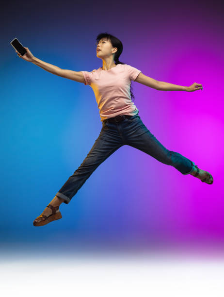 istock Asian young woman's portrait on gradient studio background in neon 1267595350