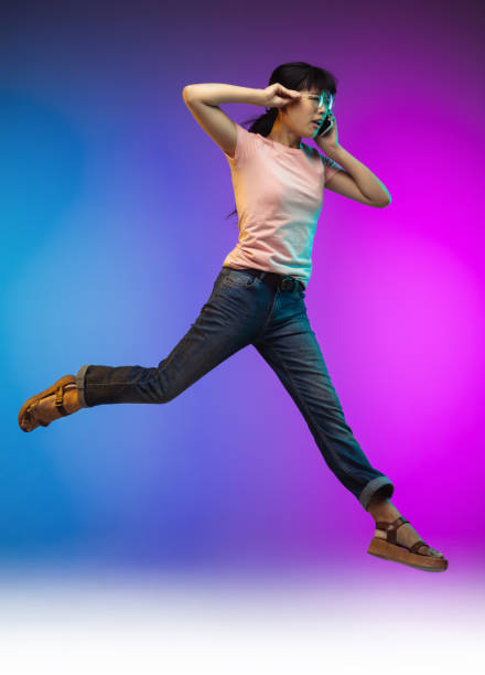 istock Asian young woman's portrait on gradient studio background in neon 1267595358