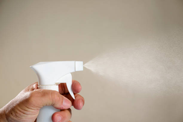 istock person applying alcohol spray for hygiene. 1267600828