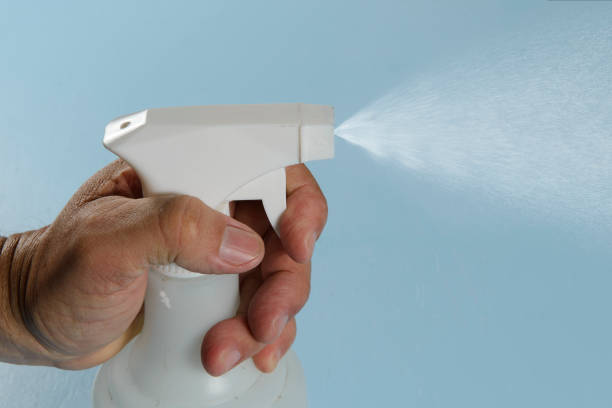 istock person applying alcohol spray for hygiene. 1267600835