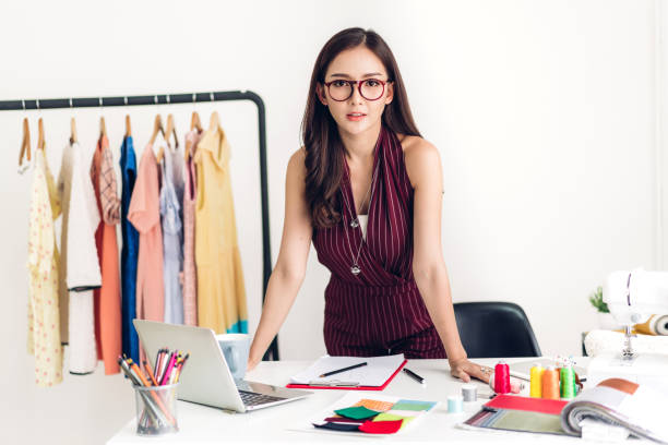 istock Smiling asia woman fashion designer working with laptop computer at workshop studio 1267602481