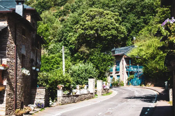 Photo of small street in the middle of a town with old houses