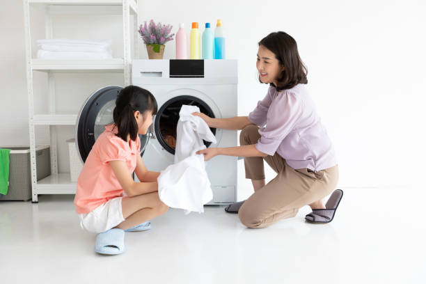 istock mother and daughter laundry at home 1267607023