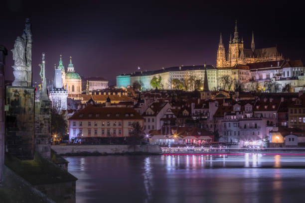 panorama de praga con puente de carlos, movimiento de barcos y río moldava por la noche – república checa - prague mirrored pattern bridge architecture fotografías e imágenes de stock