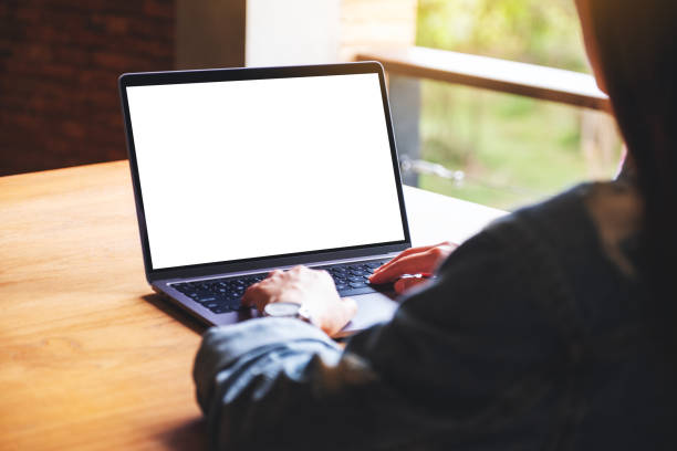 istock a woman using and typing on laptop computer keyboard with blank white desktop screen on wooden table 1267612974