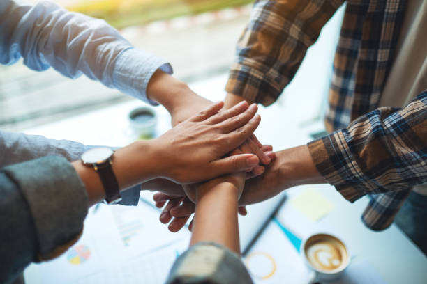 istock business team standing and joining their hands together in office 1267612976