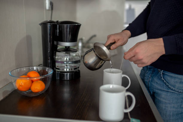 istock Man pouring a cup of tea in the kitchen 1267616352