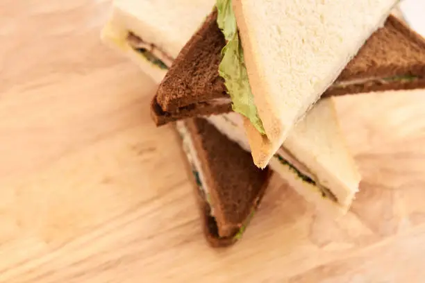 Sandwich with ham. White and black bread. Green salad